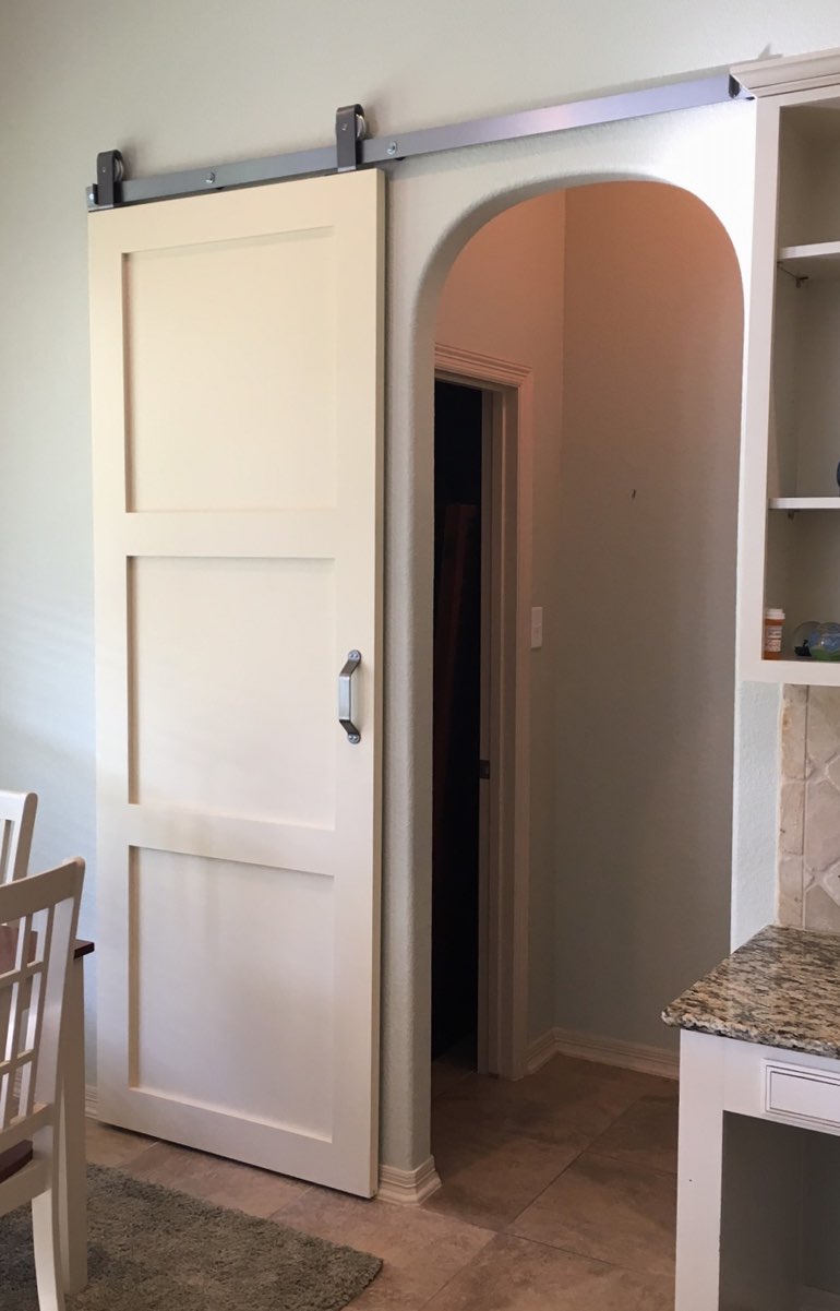 White shaker barn door covering bedroom doorway 